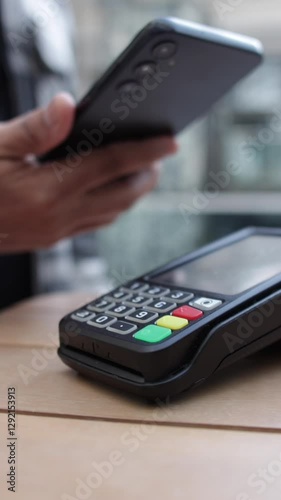 Contactless payment process highlighting customer using smartphone near pos terminal for quick, secure digital transaction inside modern cafe environment
