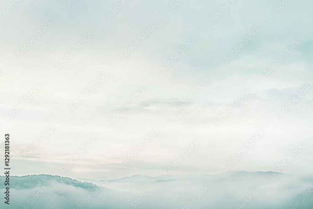 Obraz premium Serene landscape of misty mountains under a pale sky, evoking tranquility and peace