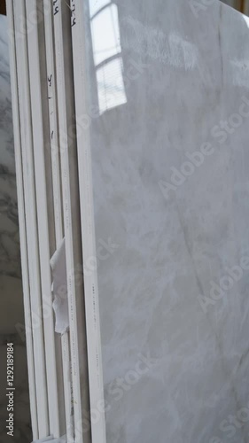 Colorful quartz and porcelain tile stone slab are standing in the factory warehouse. Kitchens and bathrooms countertop selection. Granite slabs are prepared for sale in store yard
