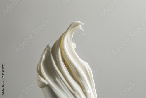 Creamy white frosting swirls on a spatula against a neutral background