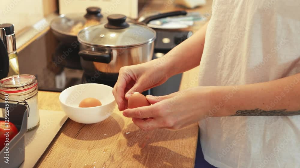 Home cook meticulously peeling boiled egg near sunlit window, preparing protein-packed ingredient with culinary expertise and delicate precision