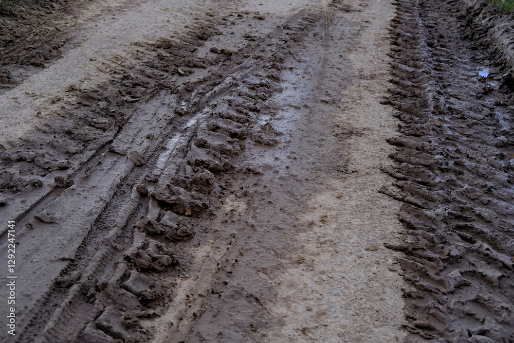 Muddy road with deep vehicle tracks after heavy rain and melting snow, Deep tire tracks in wet, muddy slush, Muddy terrain with tire impressions, challenges of off-road environments Muddy road with deep vehicle tracks after heavy rain and melting snow, Deep tire tracks in wet, muddy slush, Muddy terrain with tire impressions, challenges of off-road environments