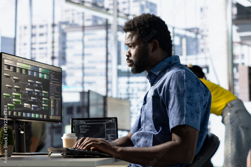 Fototapeta premium Data scientist at work creating machine learning models that can process and analyze data to improve and automate decision making processes. African american IT expert programming in office using PC