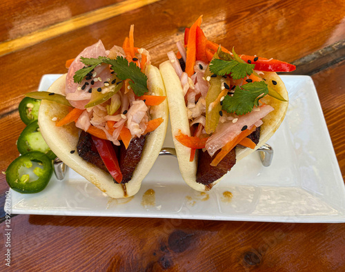 Southern fried pork buns with crispy pork, pickled vegetables, sesame seeds, cilantro and seasoned mayo.