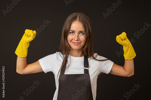 young happy housewife in apron and rubber gloves raised two fists up, joy of victory concept