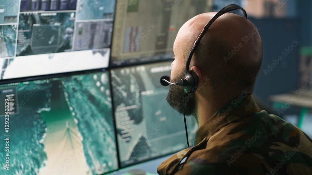 Fototapeta premium Army specialist working in war room operating surveillance tech, evaluating target data. Close up on dispatcher doing job in HQ base of operations, engaging enemy forces, camera A