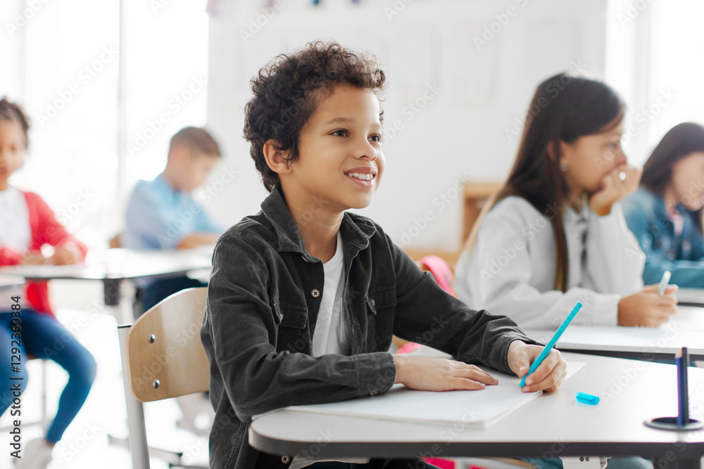 © Home-stock - Smart Latin boy listening teacher and writing in notebook, taking notes or writing final test in private school classroom © Home-stock - Smart Latin boy listening teacher and writing in notebook, taking notes or writing final test in private school classroom