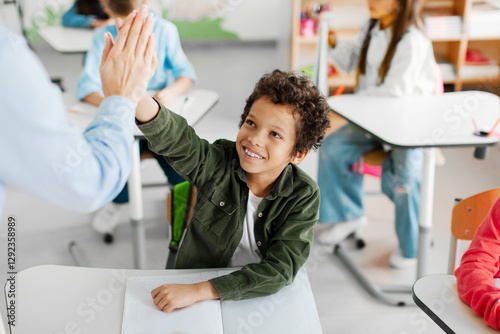 Foto Happy Latin boy giving high five to teacher, celebrating good mark for exam