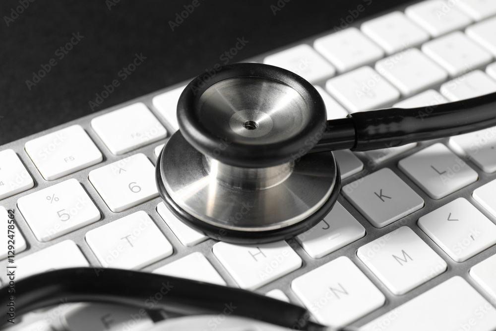 Technical support concept. Stethoscope and keyboard on black background, closeup Technical support concept. Stethoscope and keyboard on black background, closeup