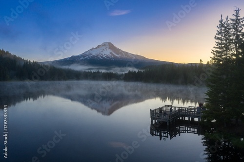 Fishermen enjoy a peaceful sunrise on a misty Trillium Lake, Mt. Hood in the background. Peaceful morning fishing.  Oregon, United States photo