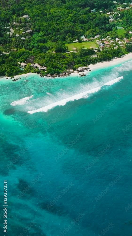 Turquoise waters along a tropical coastline with lush greenery and scattered buildings. Baie Lazare. Seychelles, Mahe. Turquoise waters along a tropical coastline with lush greenery and scattered buildings. Baie Lazare. Seychelles, Mahe.