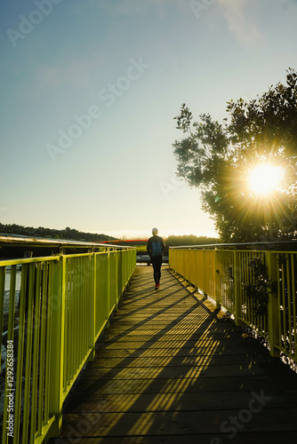 A woman with a backpack is taking a morning walk around Bascule Park, Whangarei, New Zealand.