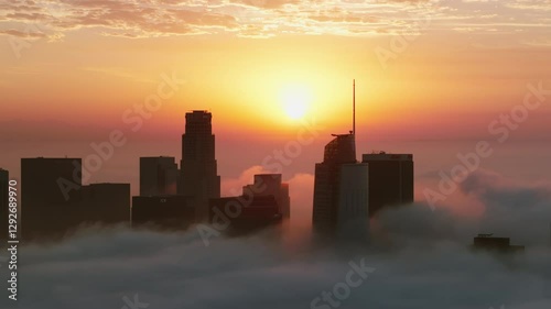 Stunning view of Downtown Los Angeles at sunrise, cloaked in fog, highlighting the iconic skyline as morning light enhances the serene atmosphere, perfect for exploration and enjoyment. LA, USA photo
