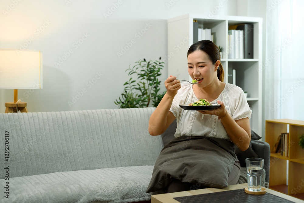 Middle aged woman enjoying a healthy meal at home Middle aged woman enjoying a healthy meal at home