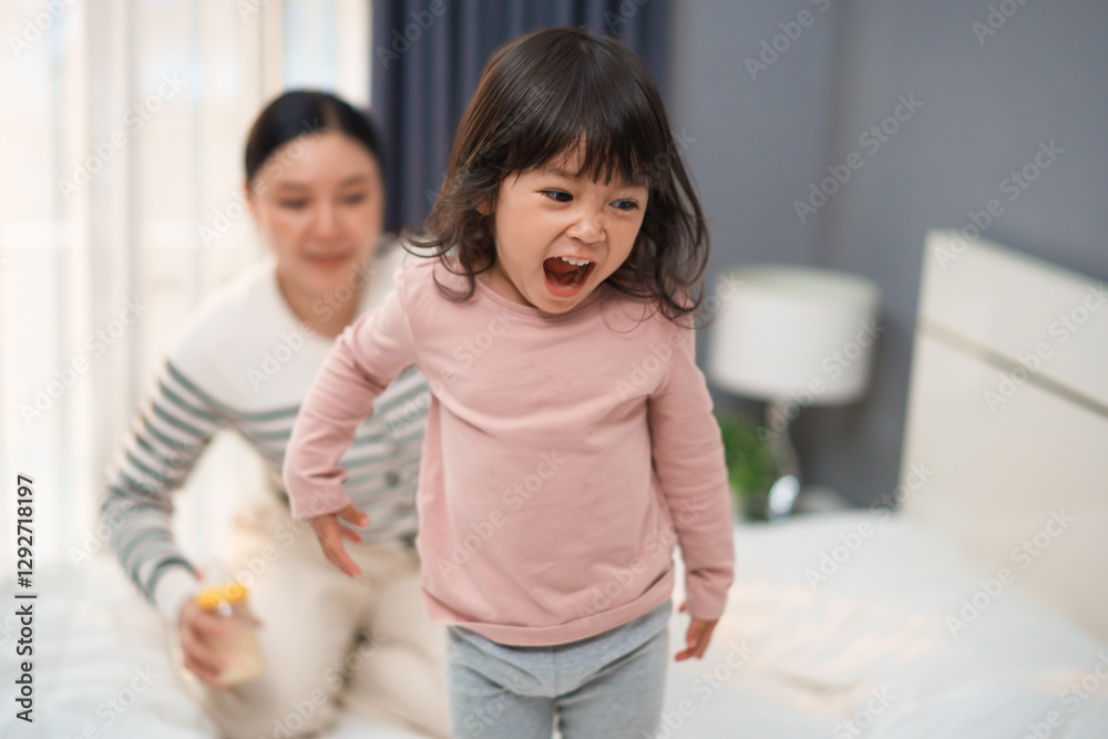 mother and toddler baby girl playing and dancing on bed mother and toddler baby girl playing and dancing on bed