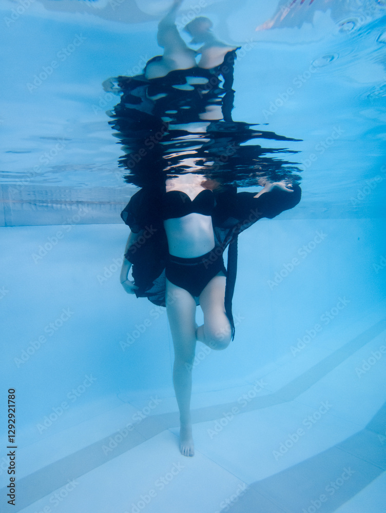 Φωτογραφία A woman is in the water wearing a black dress and a black bikini top