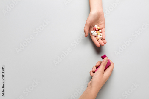 Child's hands with asthma inhaler and pills on white background photo