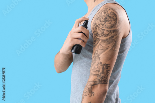 Young man spraying his tatt...