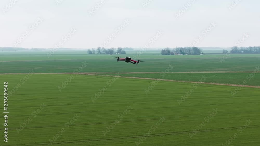 Remote controlled drone maintains a steady hover over a green field, flight capabilities Remote controlled drone maintains a steady hover over a green field, flight capabilities
