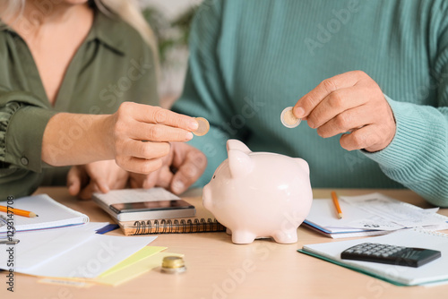 Senior couple putting coins...