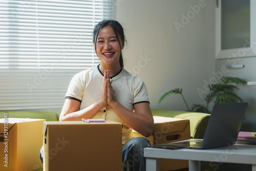 Asian woman praying with hands together while moving home
