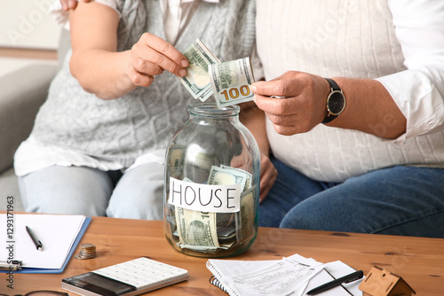 Senior couple putting money...