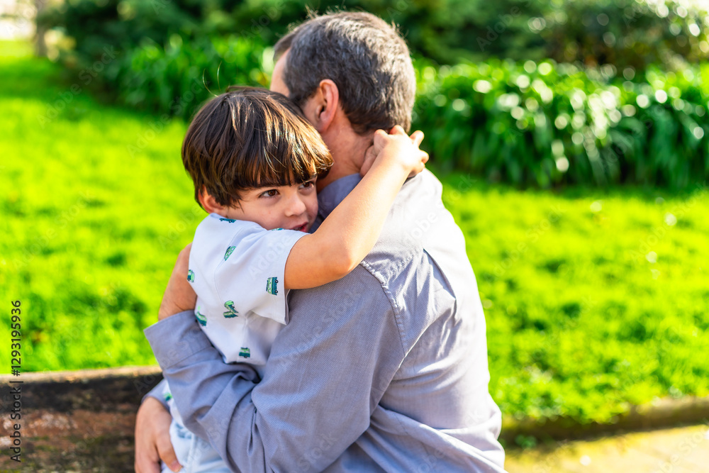 Grandfather embracing grandson in lush green park Grandfather embracing grandson in lush green park
