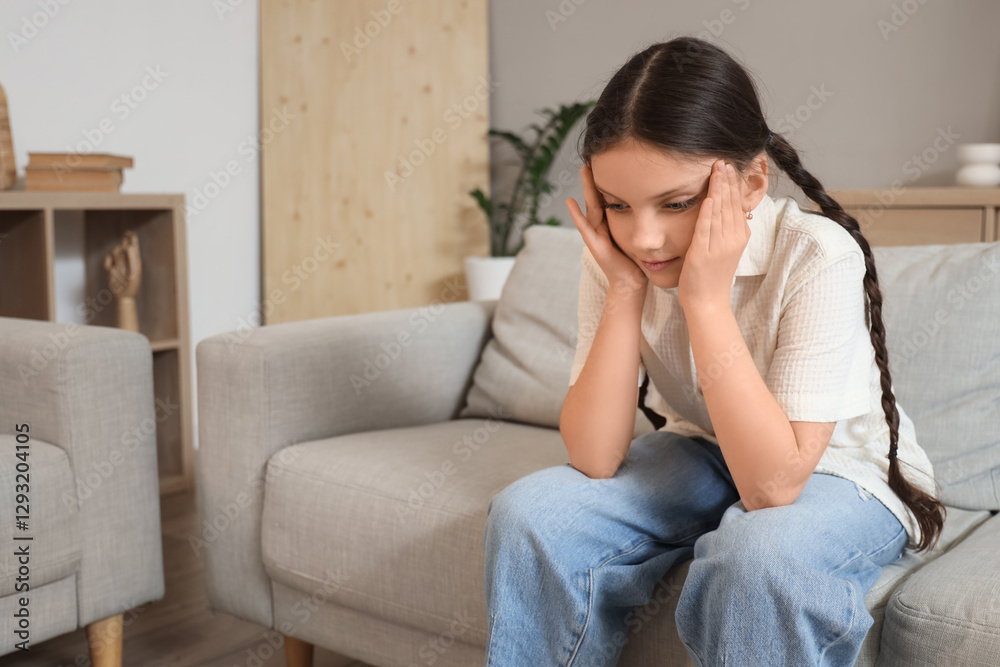 Cute girl suffering from headache on sofa at home Cute girl suffering from headache on sofa at home