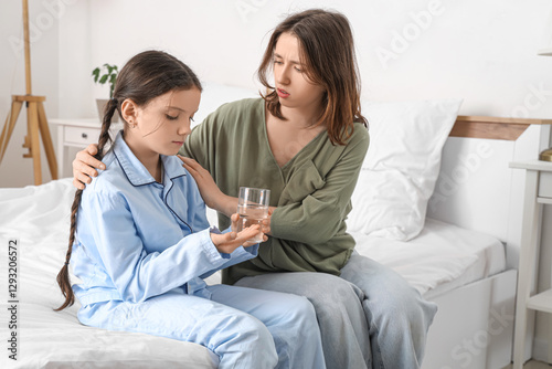 Sick girl with glass of wat...