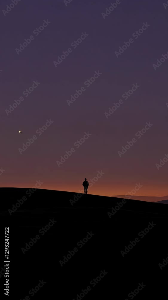 silhouette of a man walking on a beach at sunset silhouette of a man walking on a beach at sunset