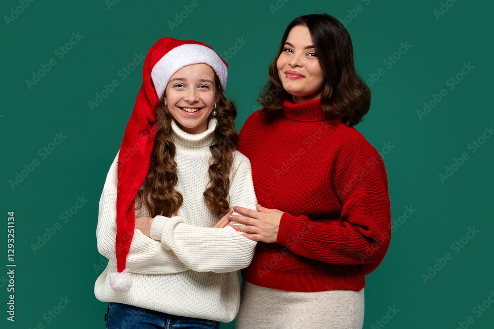 Fototapeta premium Mum and teenage daughter pose in holiday sweaters, smiling happily