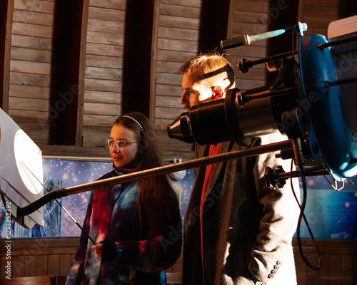 Girl and man analyze the projected Sun image from a telescope. Education activities, teaching, learning concept