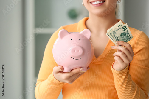 Young woman with piggy bank...