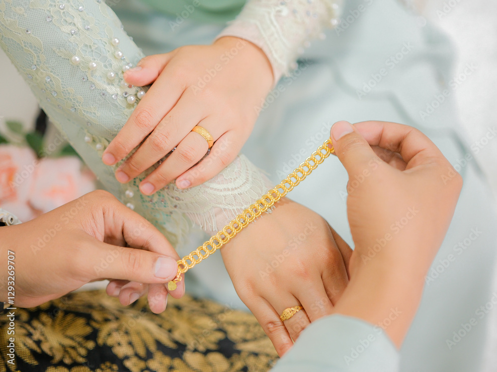 The groom put the wedding bracelet to the bride during solemnization ceremony. Family and happiness concept.