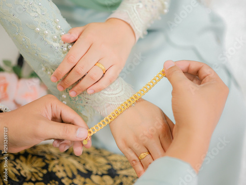 Obraz na płótnie The groom put the wedding bracelet to the bride during solemnization ceremony. Family and happiness concept. w salonie