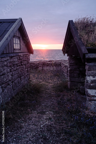 Romantischer Sonnenuntergang zwischen zwei Steinhütten mit Blick aufs Meer