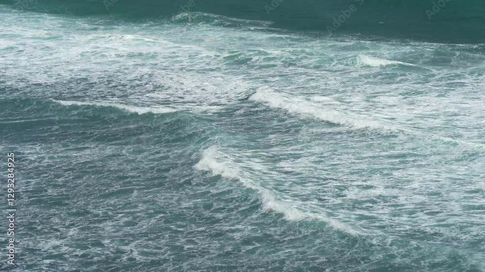Powerful ocean waves roll across the deep green sea, creating white foam and dynamic motion under natural sunlight and strong winds. Powerful ocean waves roll across the deep green sea, creating white foam and dynamic motion under natural sunlight and strong winds.