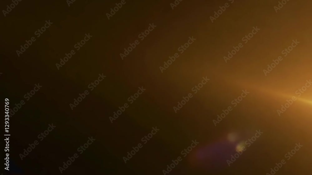 Golden light leak gradually spreading across dark background, creating warm visual transition with soft optical glimmer for video editing and motion graphic design