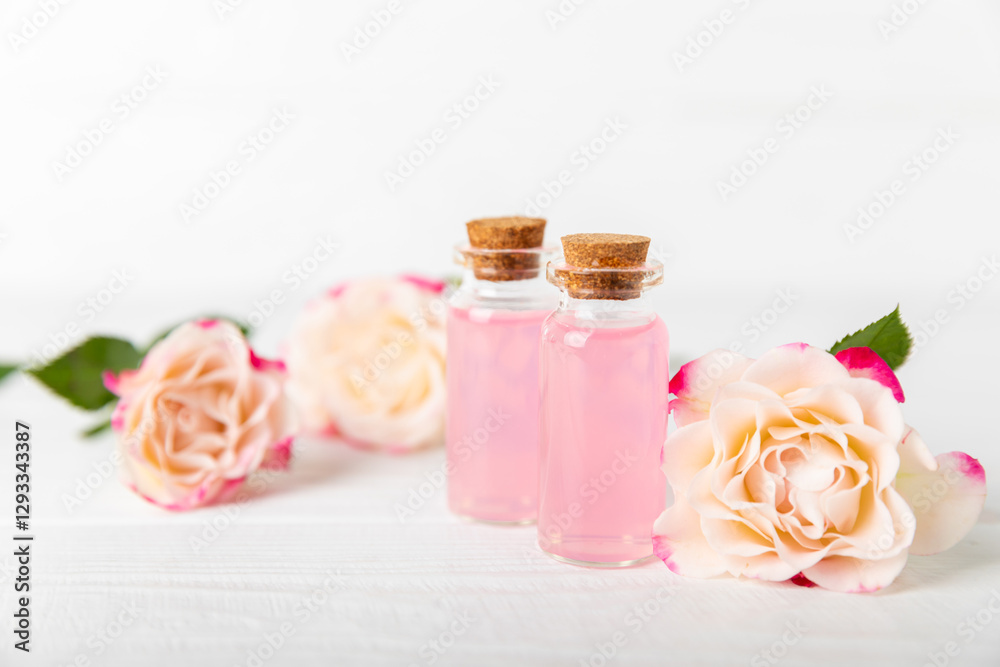 Rose essential oil on a textured background.Roses and a bottle of rose perfumed water.Aromatherapy treatment. Beauty concept. Spa procedure.Natural organic oil.Anti-stress,detox relax.Place for text