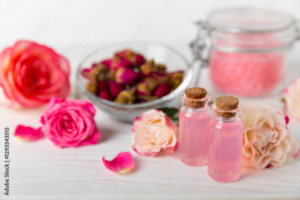 Rose essential oil on a textured background.Roses and a bottle of rose perfumed water.Aromatherapy treatment. Beauty concept. Spa procedure.Natural organic oil.Anti-stress,detox relax.Place for text Rose essential oil on a textured background.Roses and a bottle of rose perfumed water.Aromatherapy treatment. Beauty concept. Spa procedure.Natural organic oil.Anti-stress,detox relax.Place for text