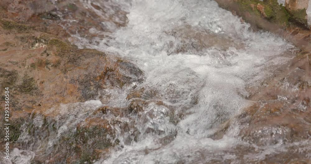Slow Motion Tilt Down Shot of Flowing Water Over Rocks Slow Motion Tilt Down Shot of Flowing Water Over Rocks