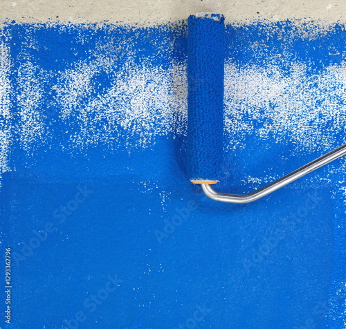 Painting a rough wall with roller. Paint roller leaving stroke of blue color over a rustic background. usable for text and messages. Blue background.