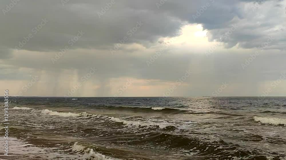 Rain in the sea. View of rain, rain clouds, sea and sea waves with white foam. Cloudy weather. Seascape. Sea landscape. Nature. Natural background Rain in the sea. View of rain, rain clouds, sea and sea waves with white foam. Cloudy weather. Seascape. Sea landscape. Nature. Natural background