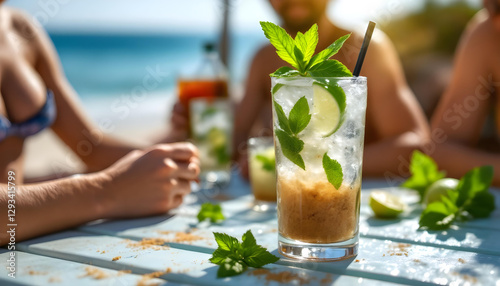 Mojito en la terraza de un chiringuito en la playa, con gente tomando el Sol. Verano