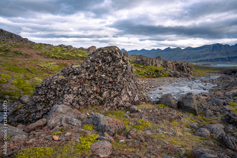 A dramatic East Iceland landscape showcases a winding river, rough rocks, and towering mountains, capturing the region’s raw and untamed beauty A dramatic East Iceland landscape showcases a winding river, rough rocks, and towering mountains, capturing the region’s raw and untamed beauty