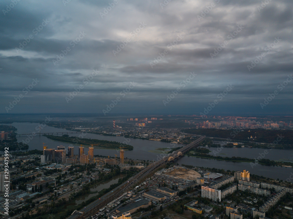 Obraz premium Aerial View of Kyiv, Ukraine – Dnipro River, Bridges and Sunset Above the Clouds