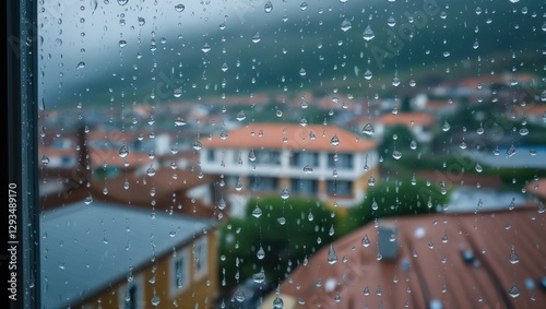 Raindrops on window with blurred town background highlighting cozy urban atmosphere during rainy day photo