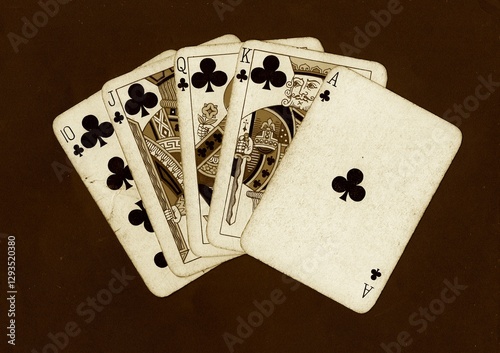 Tableau sur toile A hand of vintage playing cards in sepia on a black background.
