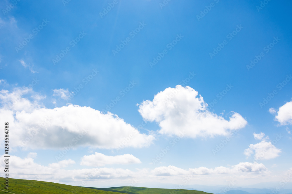 white cumulus clouds on a blue sky. horizon above mountain. wonderful nature background of atmosphere condition in day light. bright summer weather forecast. fresh air