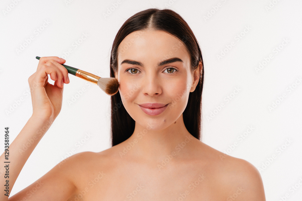 Portrait depicting a pleasant scene of an individual using a makeup brush, creating a radiant look. The focus is on personal care and beauty application in a clean and minimal setup. Portrait depicting a pleasant scene of an individual using a makeup brush, creating a radiant look. The focus is on personal care and beauty application in a clean and minimal setup.